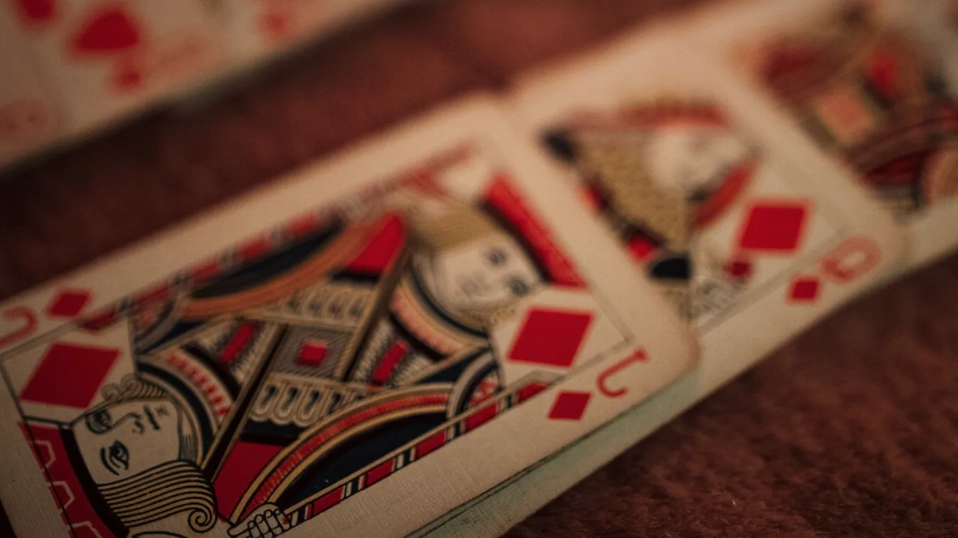 Cards being dealt across a felt table by the house dealer